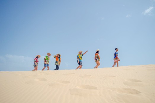 Tourists enjoying the golden sunlight on the dunes during the early morning, showcasing the best time to visit for comfortable weather on Half day desert tours Jeddah.